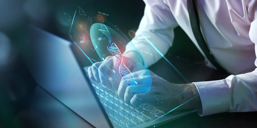 A man is working at a laptop, in front of which an infographic about the analysis of damaged DNA is projected.